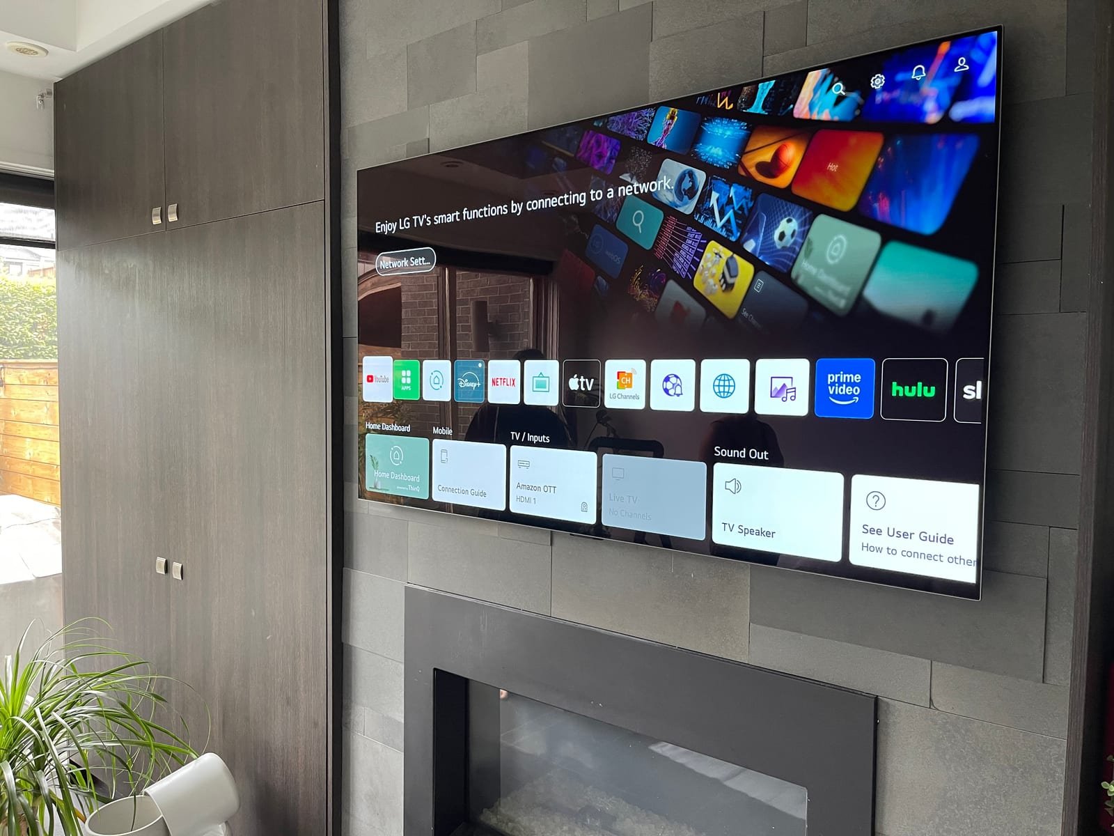 Wall-mounted TV above a modern fireplace feature wall